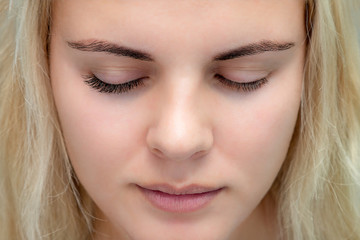 Fototapeta premium Eyelash extensions, natural volume on closed eyes to show the difference before and after procedure