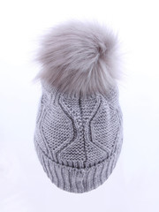 Beautiful luxury knitted hat with a gray fur on a white background