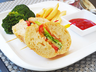 Vegetable sandwich with  french fries and ketchup on white plate