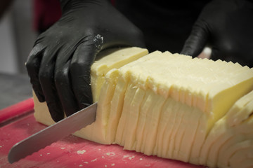 photograph cutting cheese with long knife and vignette