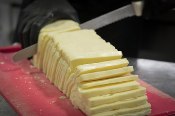 photograph cutting cheese with long knife and vignette