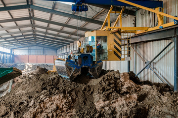 Fototapeta premium Clay for bricks. Plant for production building material with ready brick, construction industrial. Production of bricks on plant. Workflow, close-up.