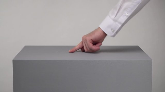 Gray ballot box. Presidential and parliamentary elections. The voter throws the ballot into the ballot box.