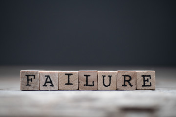 The word FAILURE on a wooden and dark background