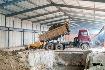 Plant for the production of bricks from clay. Plant for production building material with ready brick, construction industrial. Production of bricks on plant. Workflow, close-up. Many bricks