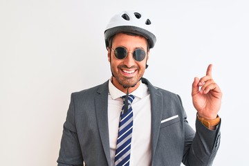 Young handsome business man wearing bike helmet and sunglasses over isolated background very happy pointing with hand and finger to the side