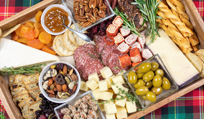 High angle closeup of charcuterie board arranged on wooden tray