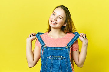 Close up portrait of a pretty young woman winking isolated yellow background
