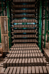 Plant for the production of bricks from clay. Plant for production building material with ready brick, construction industrial. Production of bricks on plant. Workflow, close-up. Many raw bricks