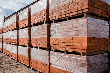 Plant for the production of bricks from clay. Plant for production building material with ready brick, construction industrial. Production of bricks on plant. Workflow, close-up. Many bricks