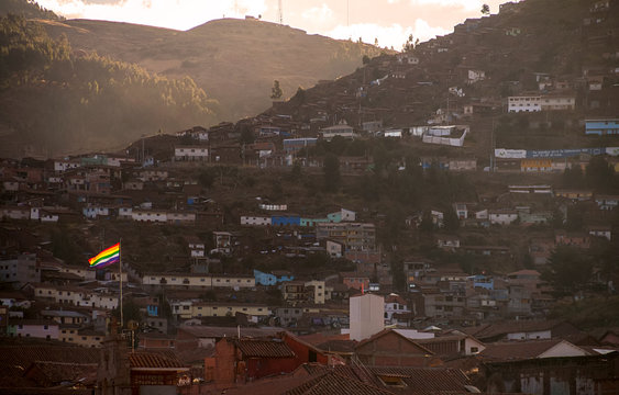 bandera  LGBT flameando en ciudad, libertad al atardecer