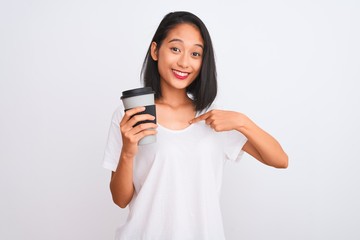 Young chinese woman drinking take away glass of coffee over isolated white background with surprise face pointing finger to himself