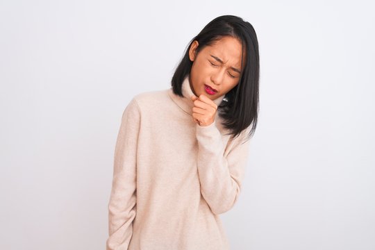 Young chinese woman wearing turtleneck sweater standing over isolated white background feeling unwell and coughing as symptom for cold or bronchitis. Healthcare concept.