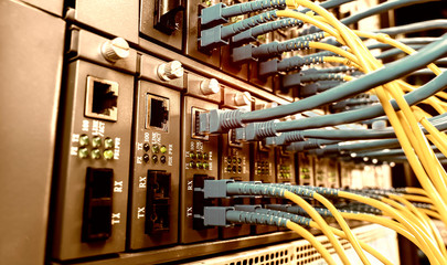 Fiber Optic cables connected to an optic ports and Network cables connected to ethernet ports