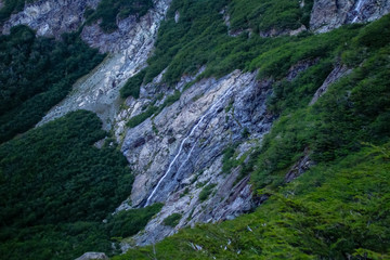 cascada cayendo entre las rocas de montaña
