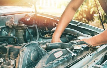 Young mechanic working use a wrench and fixing old car