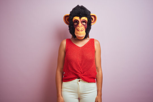 Woman standing wearing t-shirt and monkey mask