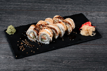 sushi set close up food for restaurant menu. black square desk plate on gray table