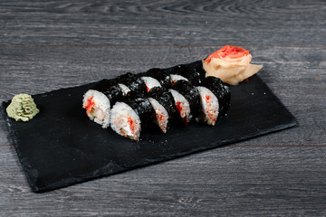 sushi set close up food for restaurant menu. black square desk plate on gray table
