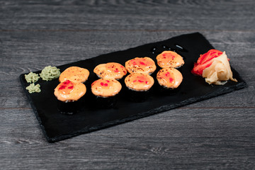 sushi set close up food for restaurant menu. black square desk plate on gray table