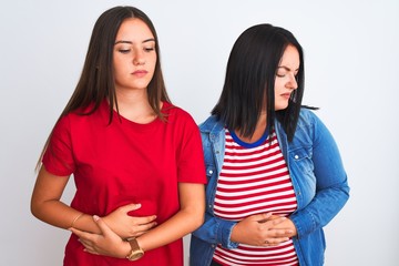 Young beautiful women wearing casual clothes standing over isolated white background with hand on stomach because indigestion, painful illness feeling unwell. Ache concept.