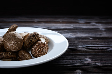 Shiitake mushrooms on the wooden background.