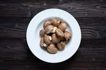 Shiitake mushrooms on the wooden background.