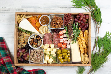 Holiday appetizer tray filled with a variety of meats, cheeses, nuts and dried fruit