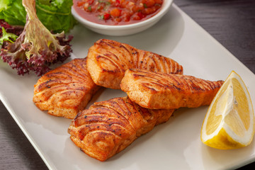 This is a hot dish of grilled red fish and tomato sauce.