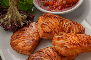 This is a hot dish of grilled red fish and tomato sauce.