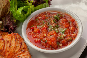This is a hot dish of grilled red fish and tomato sauce.