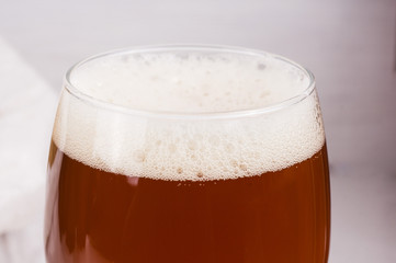beer foam in glass of home made craft beer and bag of light malt  on white background. Craft beer brewing from grain barley pale malt. Ale or lager from pilsner malt