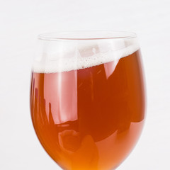 glass of home made craft beer and bag of light malt  on white backgroundCraft beer brewing from grain barley pale malt.