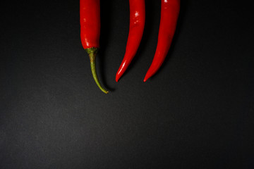Top view of red hot chili pepper over black background.