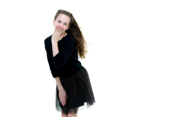 A beautiful little girl stands in the wind, her hair and clothes