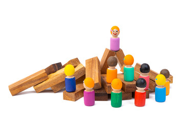 A wooden toy wooden stands on a tower and looks out at a large number of people who obey her. The concept of the ruling woman and the dictator. Images of the population and the president