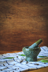 Chili peppers in stone mortar on wooden background.