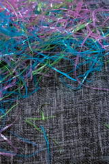 colorful plastic easter grass laying on black and white material decorating for spring