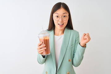 Young chinese woman drinking tomato smoothie over isolated white background screaming proud and celebrating victory and success very excited, cheering emotion