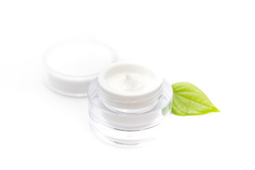 Cosmetic bottle container with green leaves, isolated on white background.