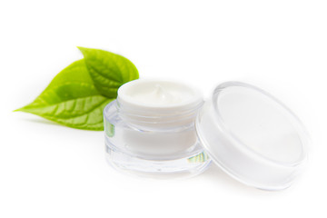 Cosmetic bottle container with green leaves, isolated on white background.