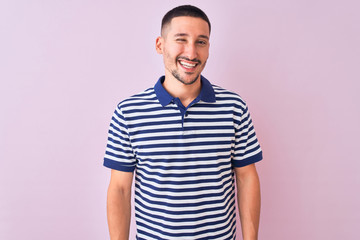 Young handsome man wearing nautical striped t-shirt over pink isolated background winking looking at the camera with sexy expression, cheerful and happy face.