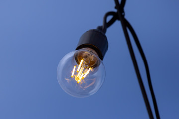 burning lamp on the background of blue sky