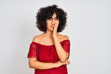 Young arab woman with curly hair wearing red dress standing over isolated white background thinking...