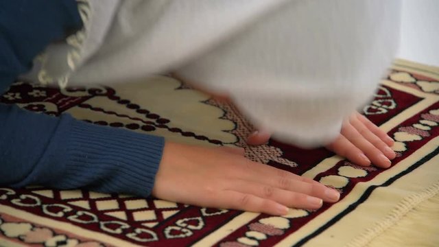Caucasian Muslim Woman Prostrating and Praying on Carpet, Close Up