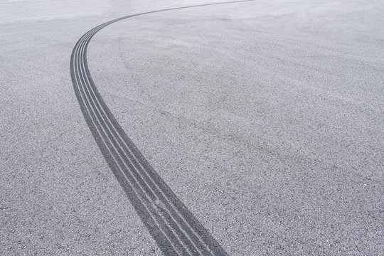 Curved tyre track on asphalt with copy space