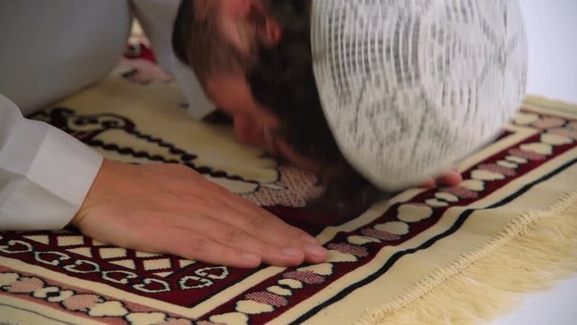 Caucasian Muslim Man Prostrating and Praying on Carpet, Close Up
