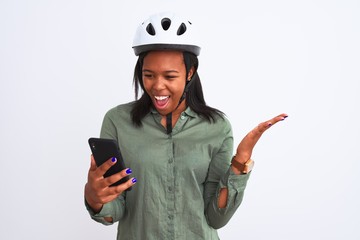 Young african american woman wearing bike helment and using smartphone very happy and excited, winner expression celebrating victory screaming with big smile and raised hands