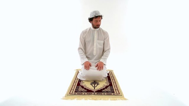 Muslim Male Performing Taslim and Praying on Carpet, White Background