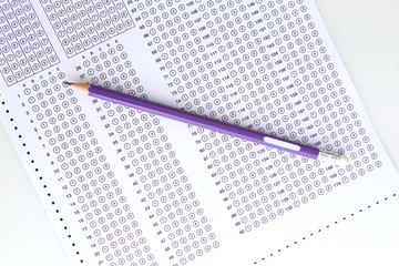 Student filling out answers to purple answer sheet with purple pencil.